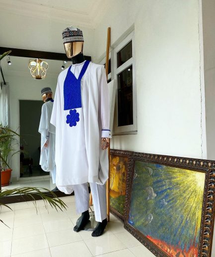 A white Agbada with royal blue embroidery detailing and royal blue Swarovski stone with hand woven Aboki hat