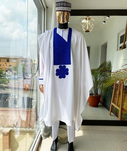 A white Agbada with royal blue embroidery detailing and royal blue Swarovski stone with hand woven Aboki hat