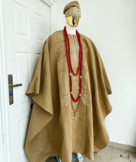 A champagne gold aso oke regal agbada, dashiki, sokoto, red and gold mix coral bead, matching hand woven Yoruba hat, and a long gold chain with a Jesus piece.