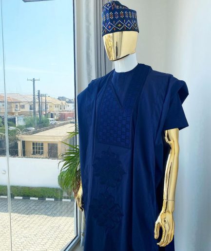 A navy blue aso oke dashiki with a floral and box-shaped embroidery design and hand-embroidered Yoruba hat