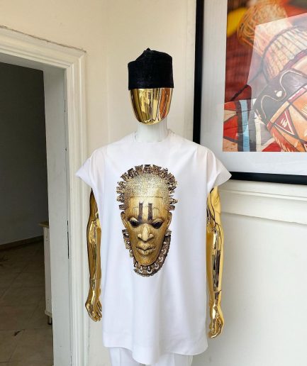 A white “daftan” with the Benin royalty prints and black Fulani hat