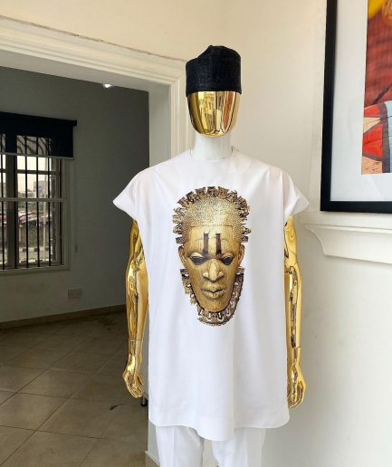 A white “daftan” with the Benin royalty prints and black Fulani hat