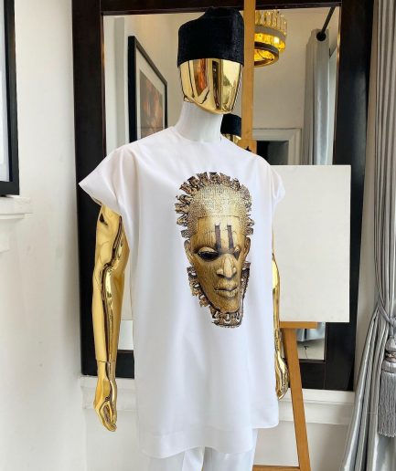A white “daftan” with the Benin royalty prints and black Fulani hat