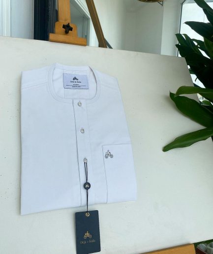 A white, clear view, transparent Swarovski buttons, front flap, and patch pocket detail African traditional senator Kaftan native.