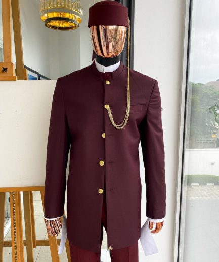 A Reloaded Ceremonial “Ayeye” Ijade 20/21 - Look 10- “Ajala”. A burgundy safari jacket with gold buttons, inner waist coat, turtle neck shirt, hat and pant trousers.