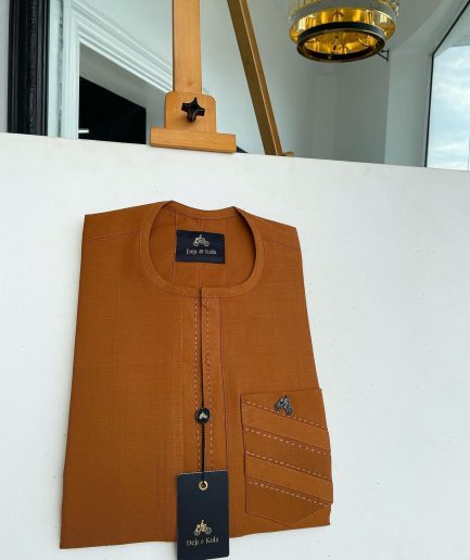 A ginger orange, mid section embrodery front flap with a symmetric lane patch pocket African traditional kaftan native.