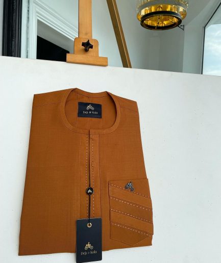 A ginger orange, mid section embrodery front flap with a symmetric lane patch pocket African traditional kaftan native.