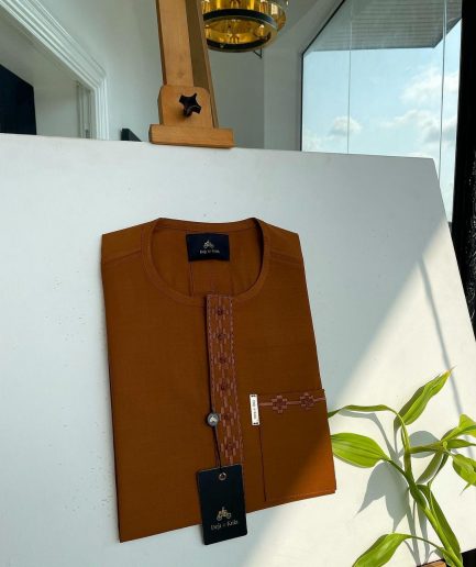 A caramel brown flap and pocket undulating with connected lane embroidery detailing African traditional senator Kaftan native
