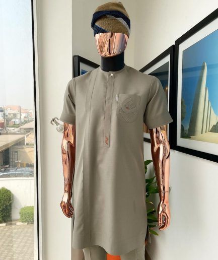 A Sand dollar beige, clear view Swarovski button with orange embroidery flap and pocket detailing African traditional senator kaftan native.