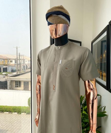 A Sand dollar beige, clear view Swarovski button with orange embroidery flap and pocket detailing African traditional senator kaftan native.