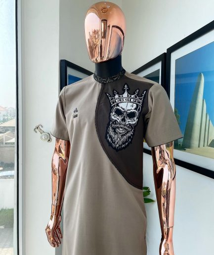 An almond ivory and cedar brown, black and gold metallic Jacquard neck and crown skull embroidery punk biker patch detailing African traditional senator Kaftan native.