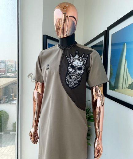 An almond ivory and cedar brown, black and gold metallic Jacquard neck and crown skull embroidery punk biker patch detailing African traditional senator Kaftan native.