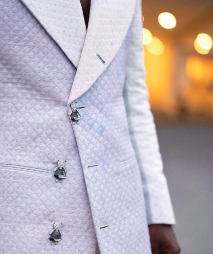 A monochrome, peak lapel, light multi-color dyed trench double breasted jacquard with bunny button details suit