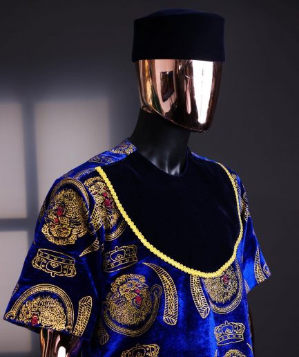 An “isiagu” gold, blue with matching fringe details, short sleeve, hat and velvet pant African traditional native.