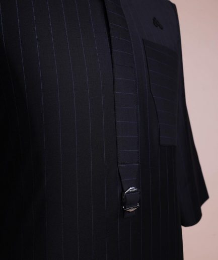 A black pencil stripe, mug-shaped pocket, front flap with buckle strap and silver Swarovski button, 3/4 sleeve African senator kaftan.