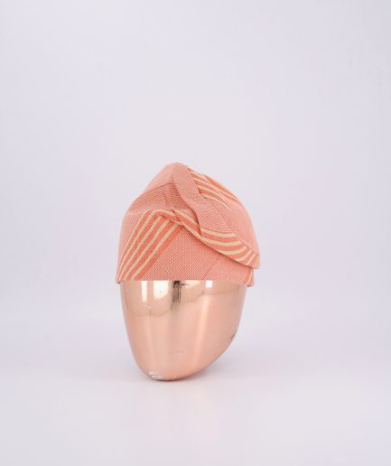 A soft peach Yoruba fila with subtle gold-striped detailing.